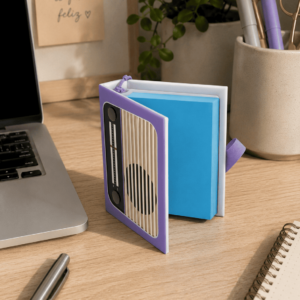 Porta post-it retrô Genevie com capa de rádio antigo roxo sobre mesa de escritório com laptop e plantas